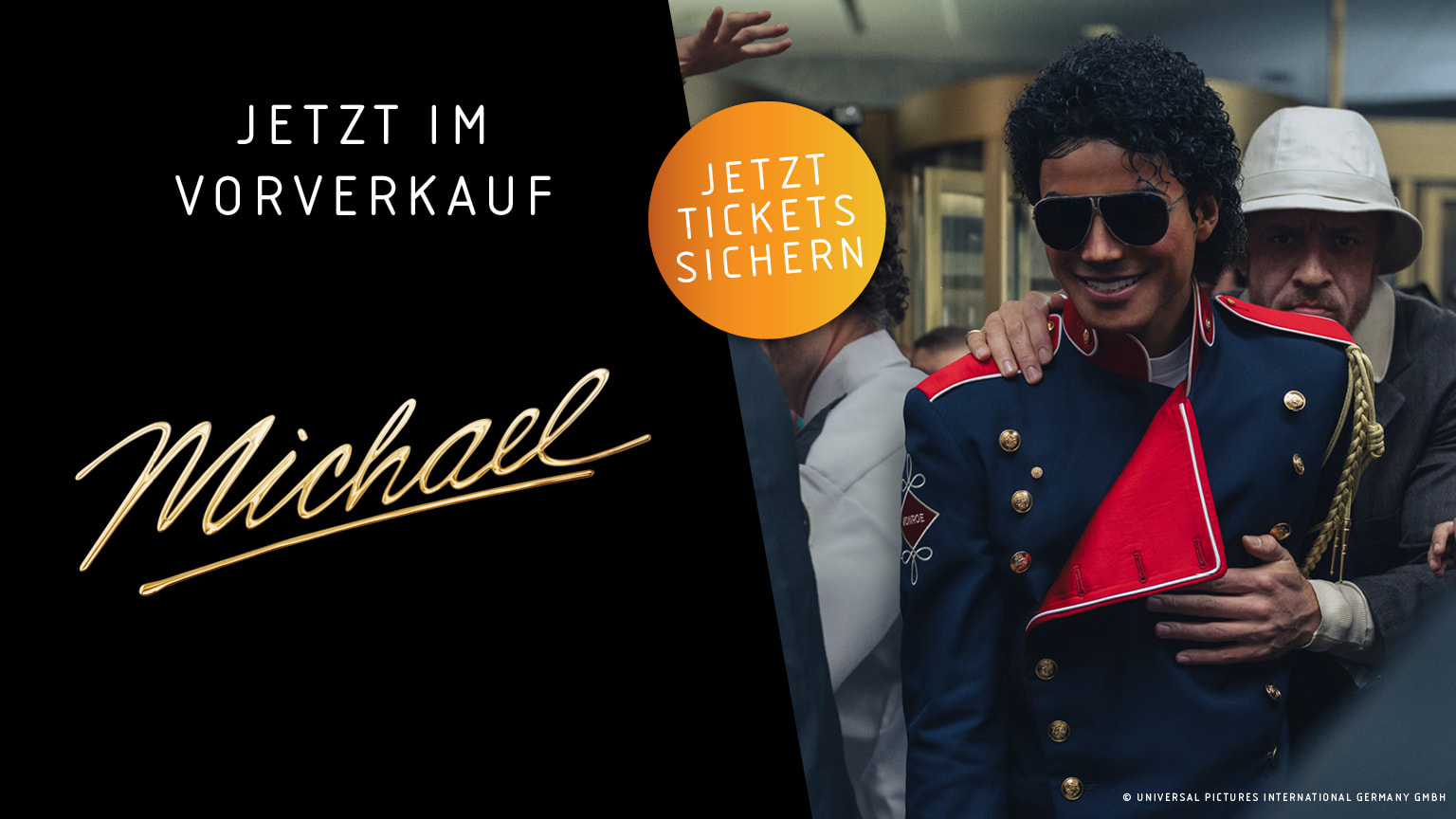 Ein Mann im Stil von Michael Jackson trägt eine auffällige rot-blaue Militärjacke mit goldenen Knöpfen und eine dunkle Sonnenbrille, während er von Menschen umgeben ist und sich durch eine Menge bewegt. Unten im Bild steht auf schwarzem Hintergrund in deutscher Sprache „Jetzt Tickets sichern“ und „Jetzt im Vorverkauf“, daneben der Schriftzug „Michael“.